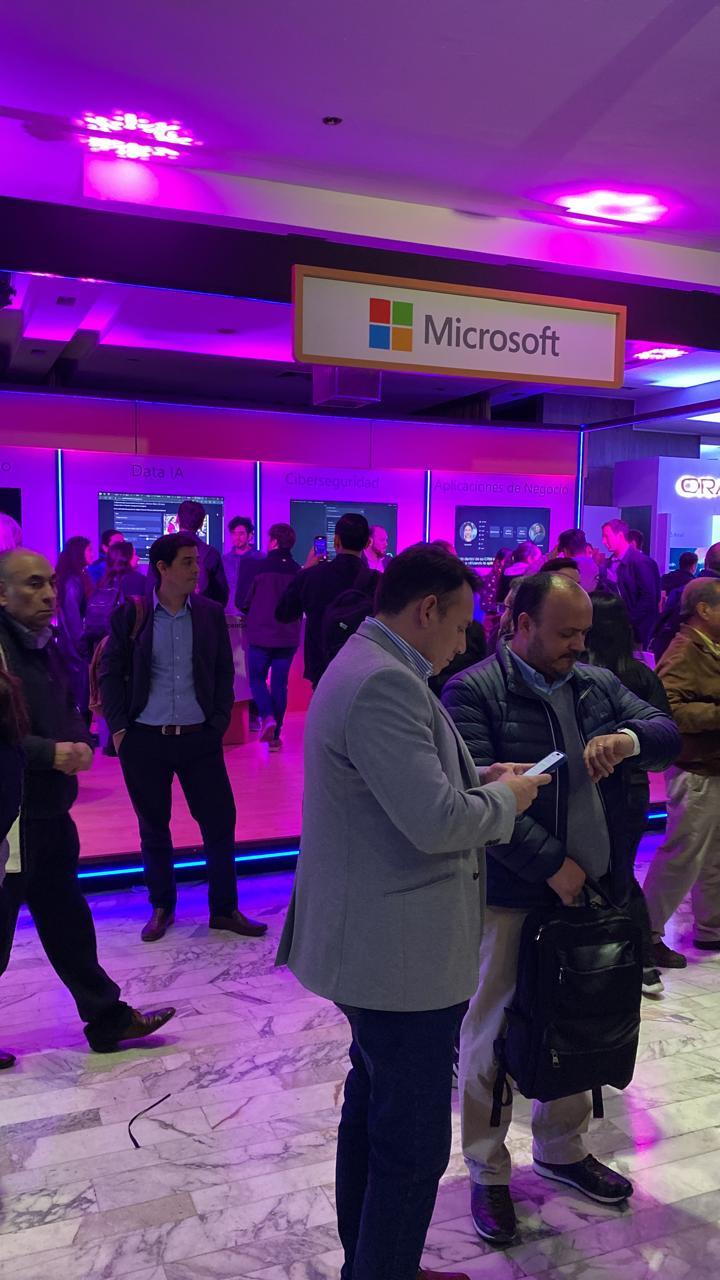 Stand de Microsoft en una feria de tecnología con asistentes recorriendo el lugar