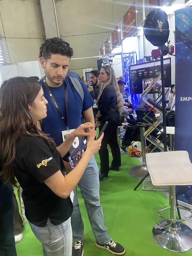 Integrante de Código Startup conversando con una visitante en una feria tecnológica